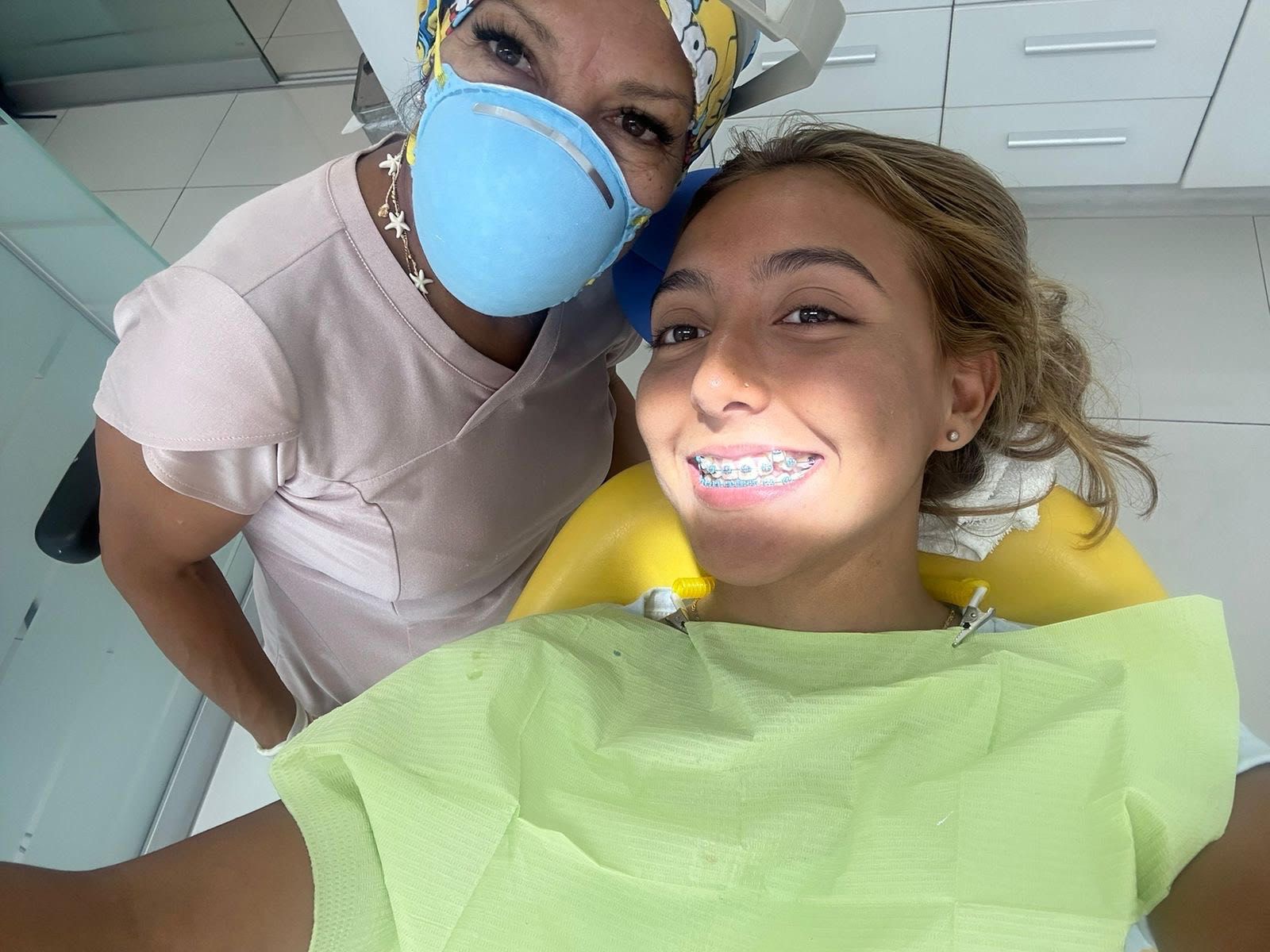 Una mujer se toma una selfie con un dentista mientras usa una máscara.