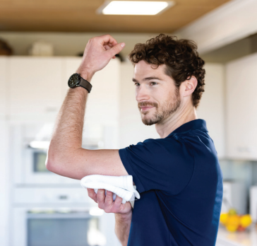 A man in a blue shirt is flexing his arm