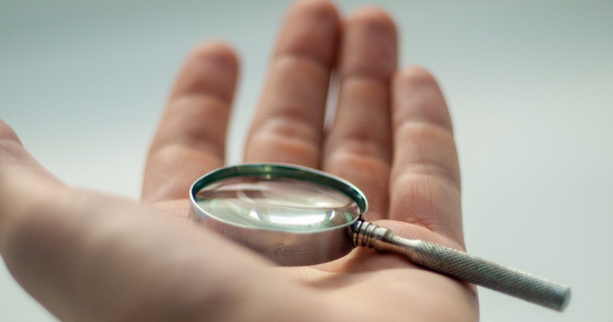 A person is holding a magnifying glass in their hand.