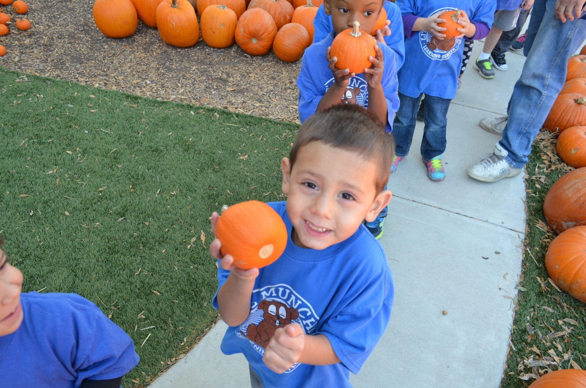 Kid Holding Pumpkins — Austin, TX — Little Munchkins Learning Center