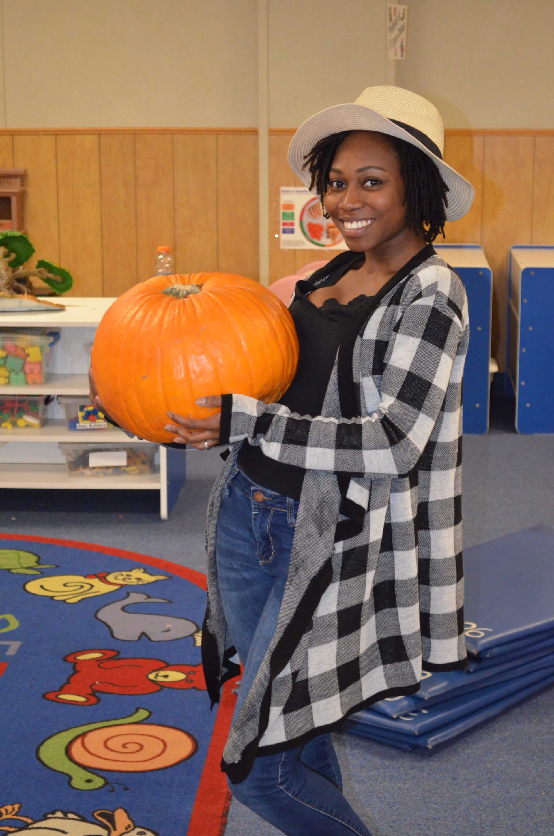 Woman Holding Pumpkin — Austin, TX — Little Munchkins Learning Center