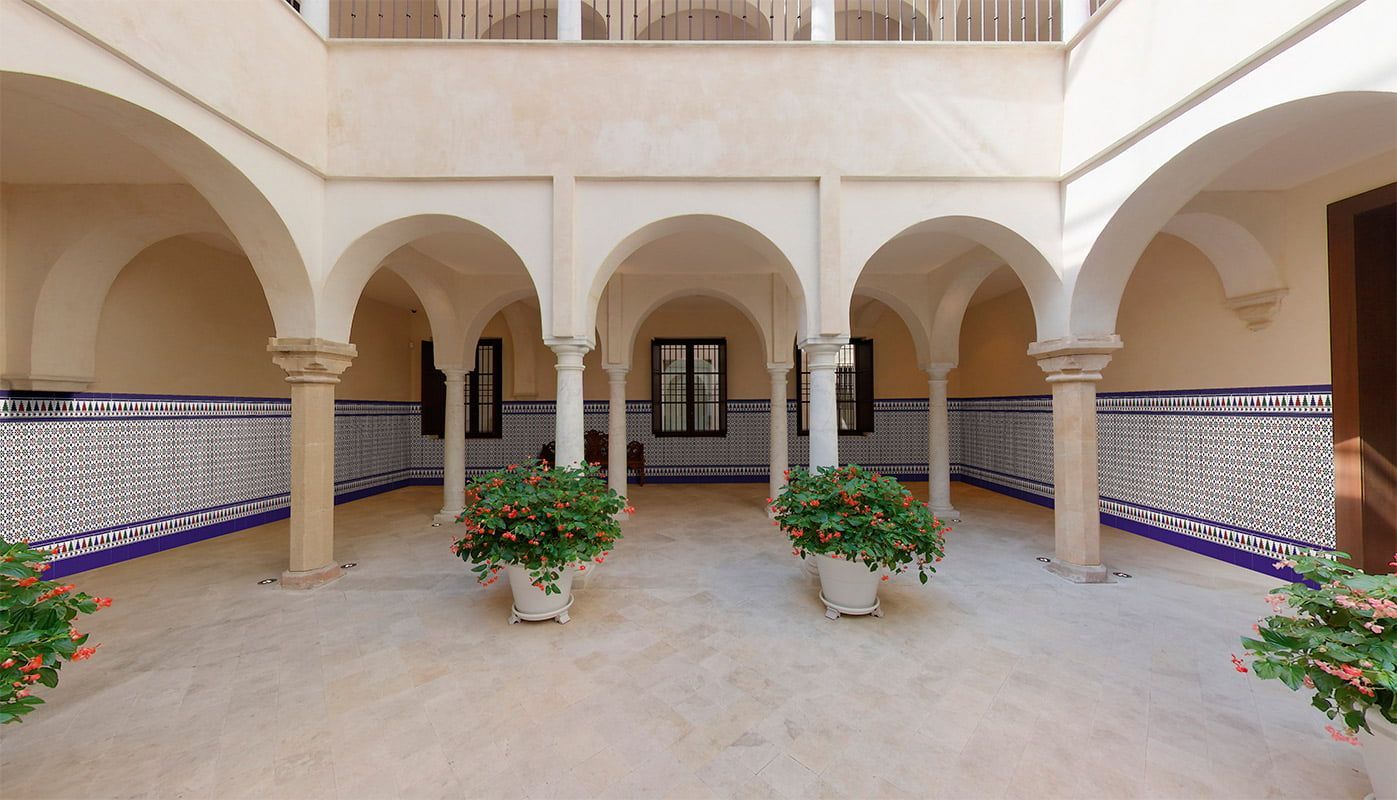 Un cortile con archi e fiori in vaso