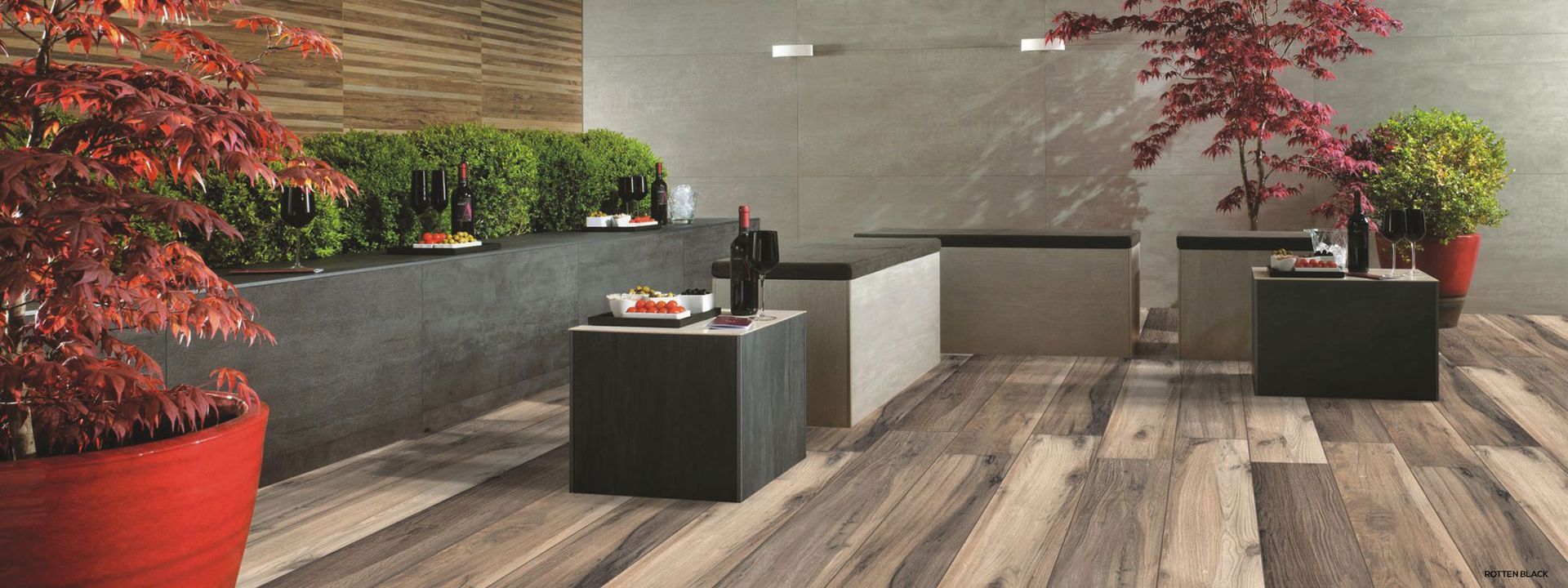 Una stanza con pavimento in legno, tavoli e piante in vaso.