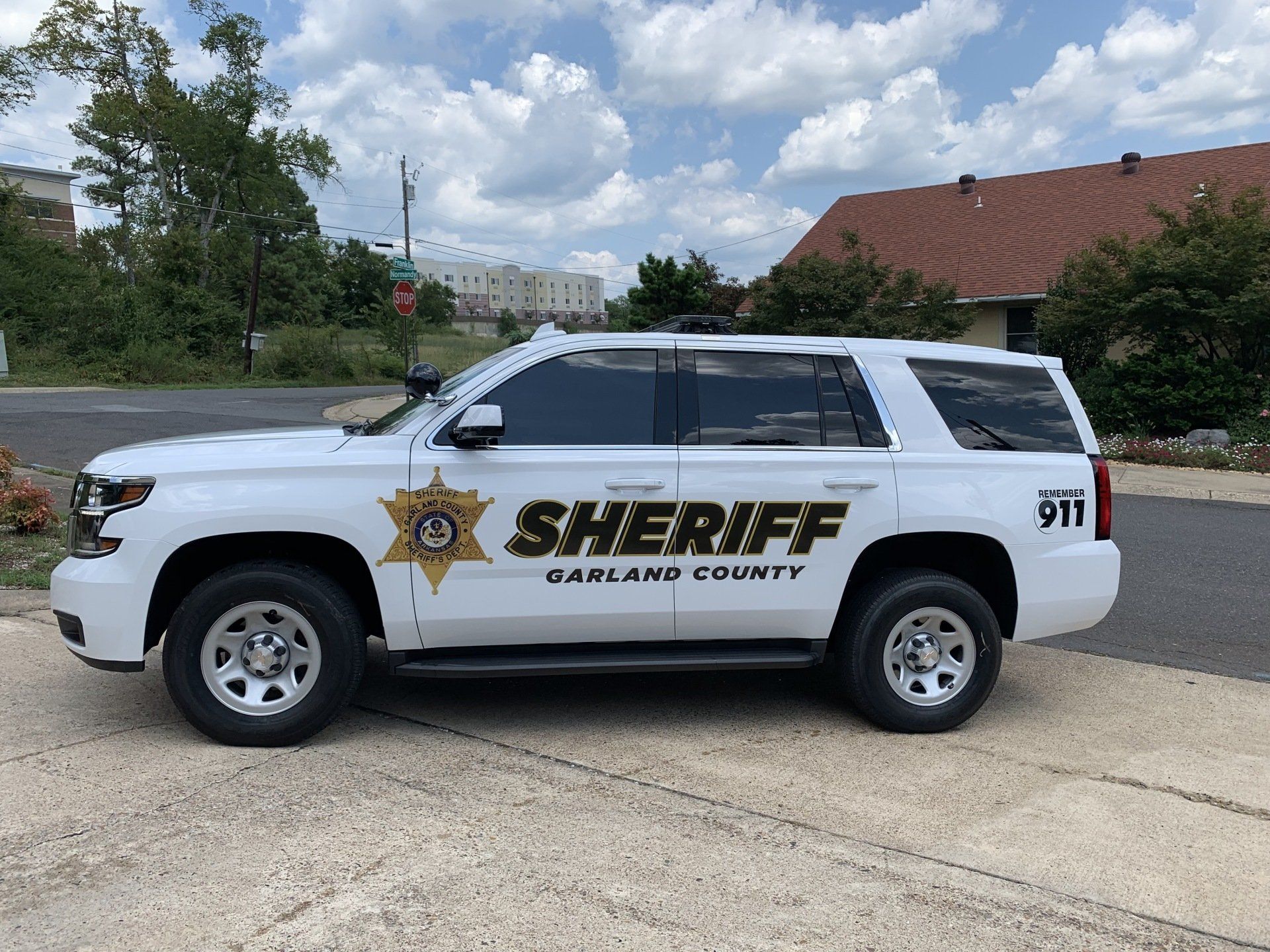 White Oakland County Sheriff SUV parked on a paved area, cloudy sky in the background.