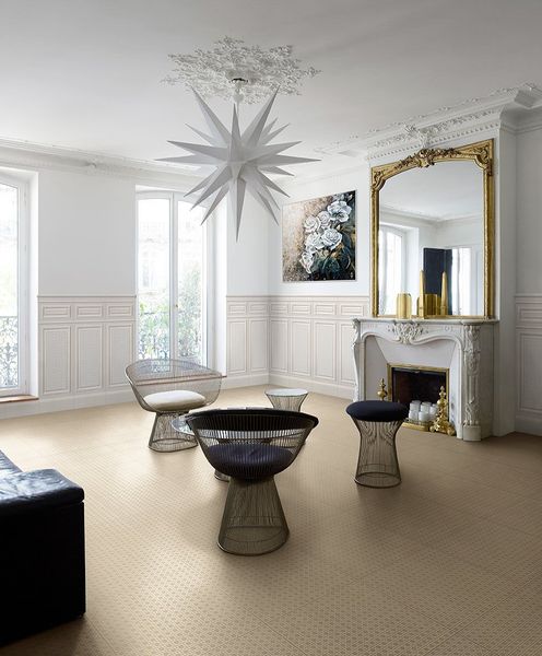 Soggiorno con moquette color cuoio, pareti bianche, specchio decorato e mobili moderni.