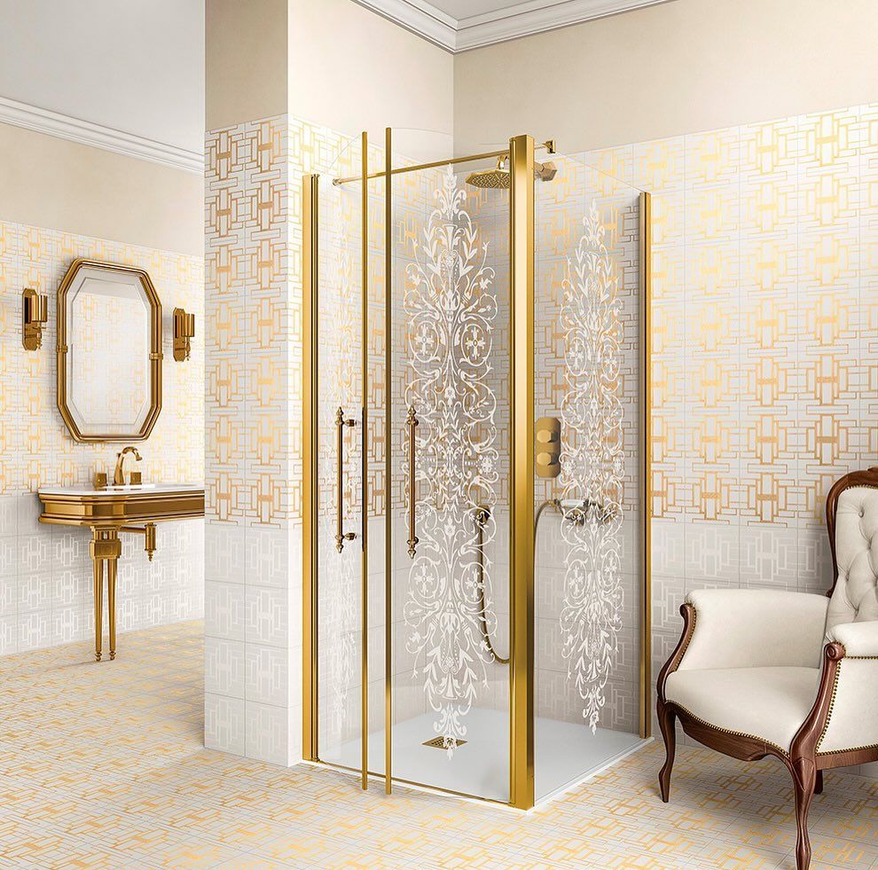 Doccia con cornice dorata e motivo floreale inciso in un lussuoso bagno con dettagli dorati e una sedia.