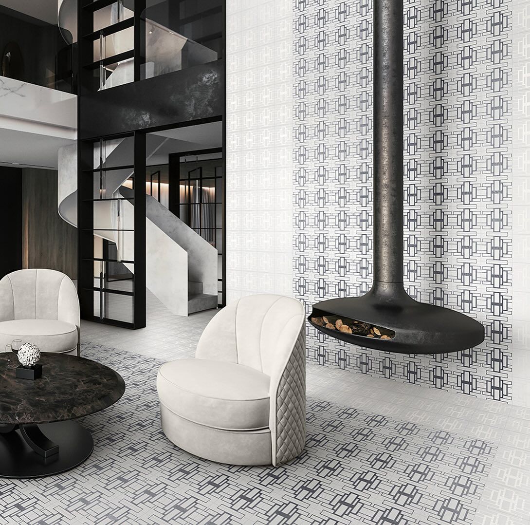 Soggiorno moderno con camino, sedie bianche e tappeto a fantasia.