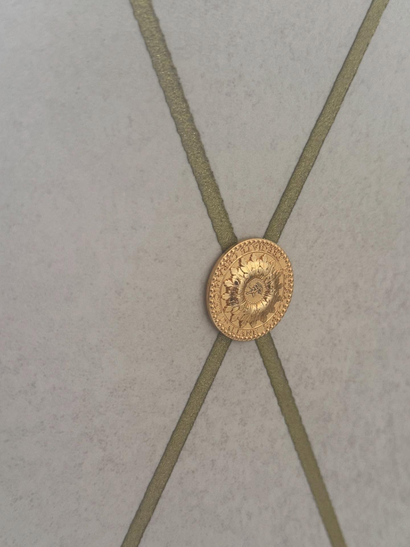 Dettaglio di parete bianca con motivo a rombi, impreziosita da borchie dorate.