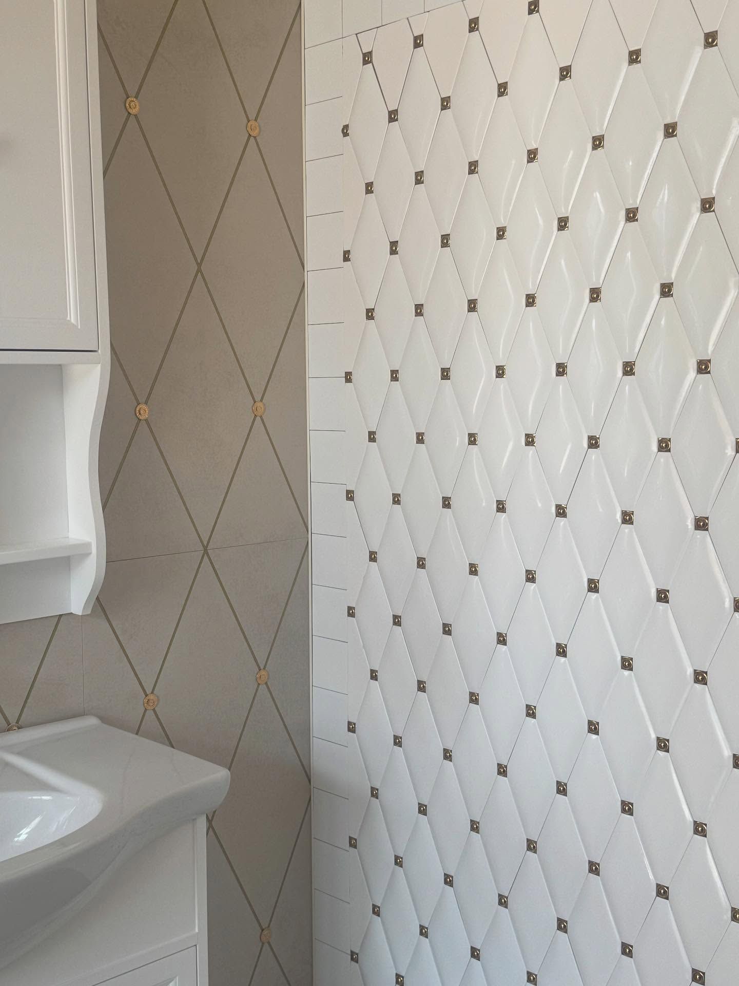 Parete bianca con motivo a rombi, impreziosita da borchie dorate.