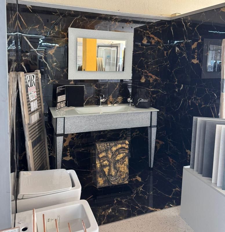 Bagno con piastrelle in marmo nero, lavandino bianco, specchio