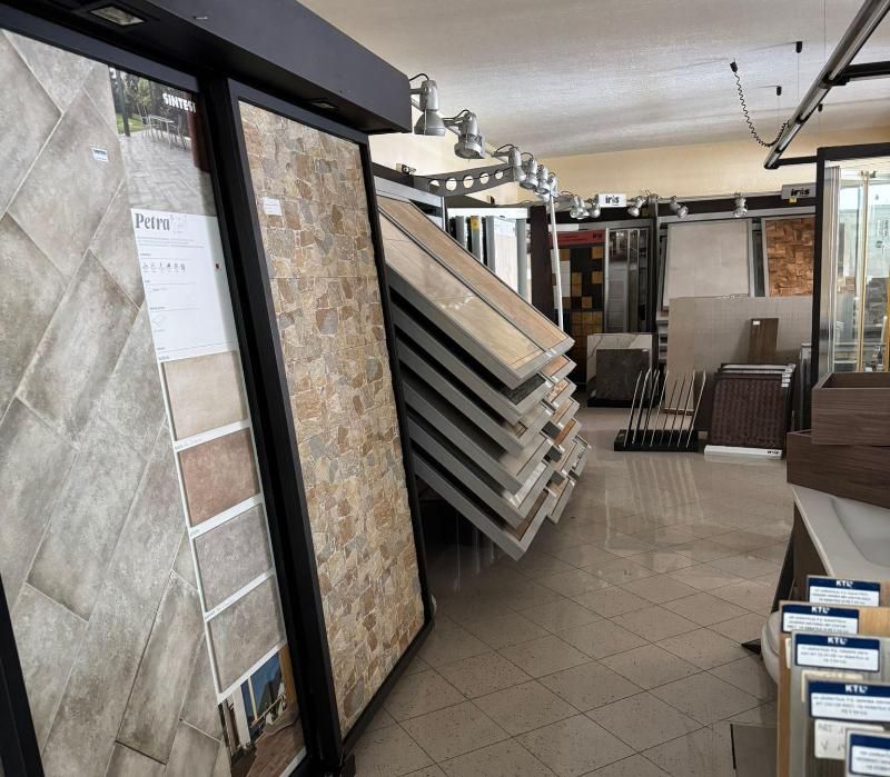 Interno dello showroom di piastrelle con varie esposizioni di piastrelle e illuminazione.