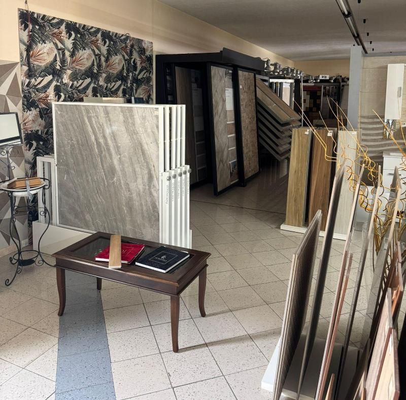 Showroom con campioni di piastrelle. Vari colori e fantasie esposti, spazio interno.
