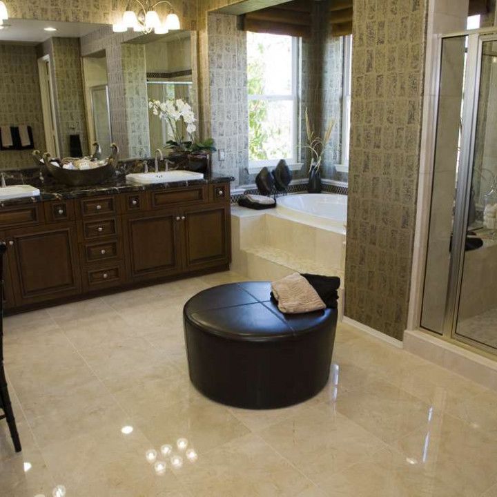 A bathroom with two sinks and a round ottoman