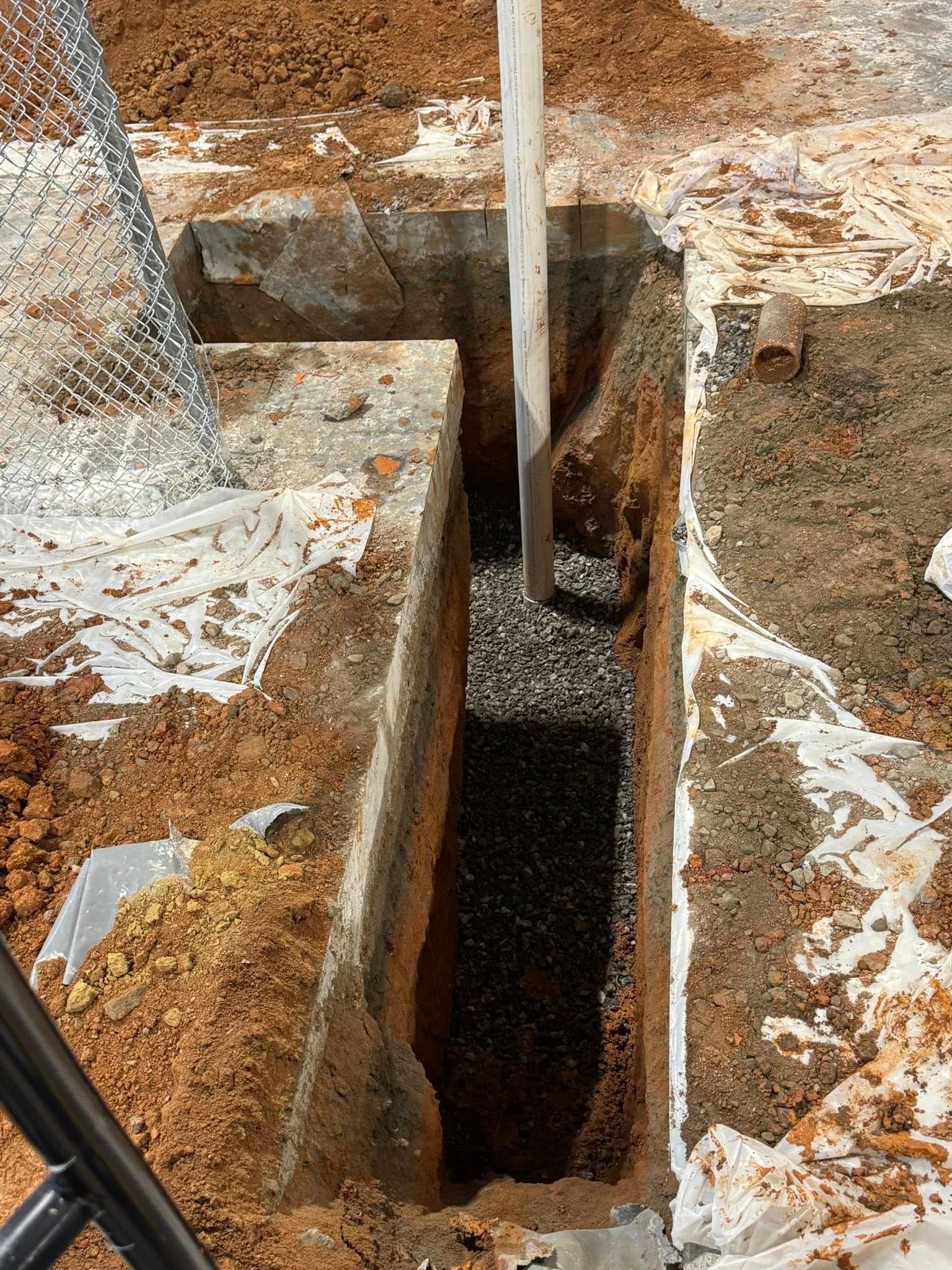 A pipe is being poured into a hole in the ground.