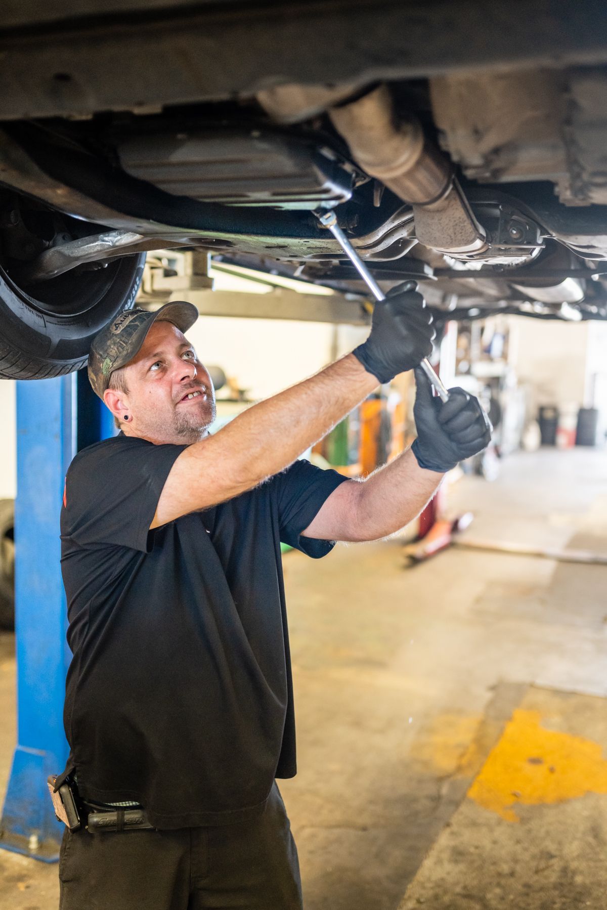 Mechanic Repairing Vehicle Undercarriage With Wrench | Motorworks of Florida