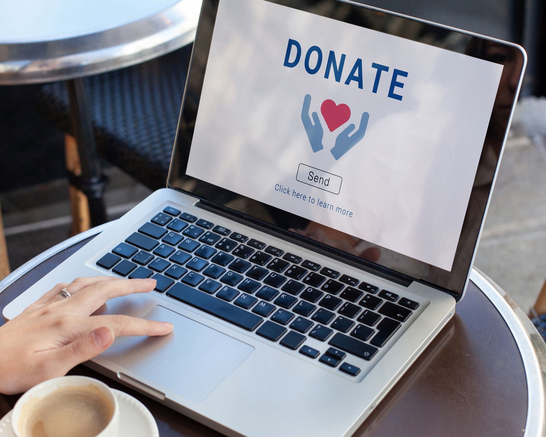 A person is typing on a laptop that says donate on the screen