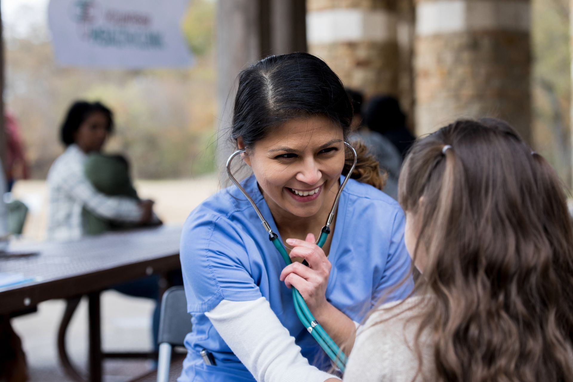 A nurse is listening to a child 's heartbeat with a stethoscope.