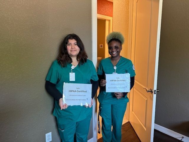 Two nurses standing next to each other holding certificates