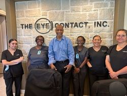 A group of people standing in front of a wall that says the eye contact inc.