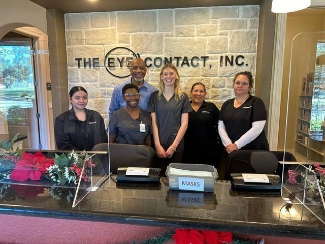 A group of people standing behind a counter at the eye contact inc.