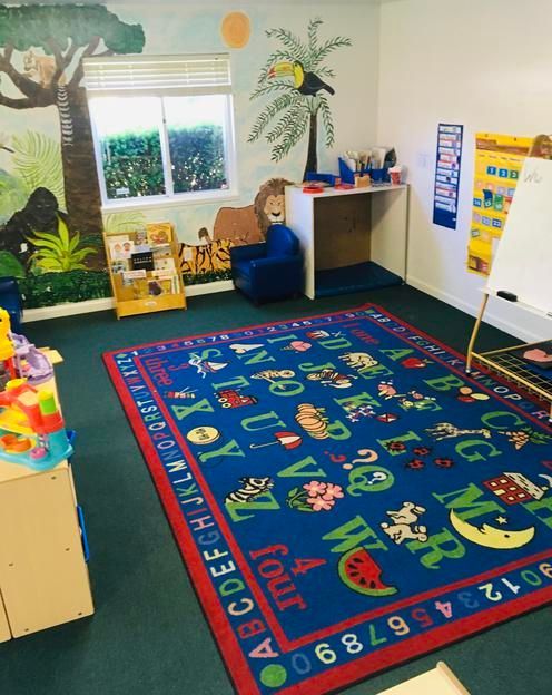 A room with a blue rug that has the alphabet on it
