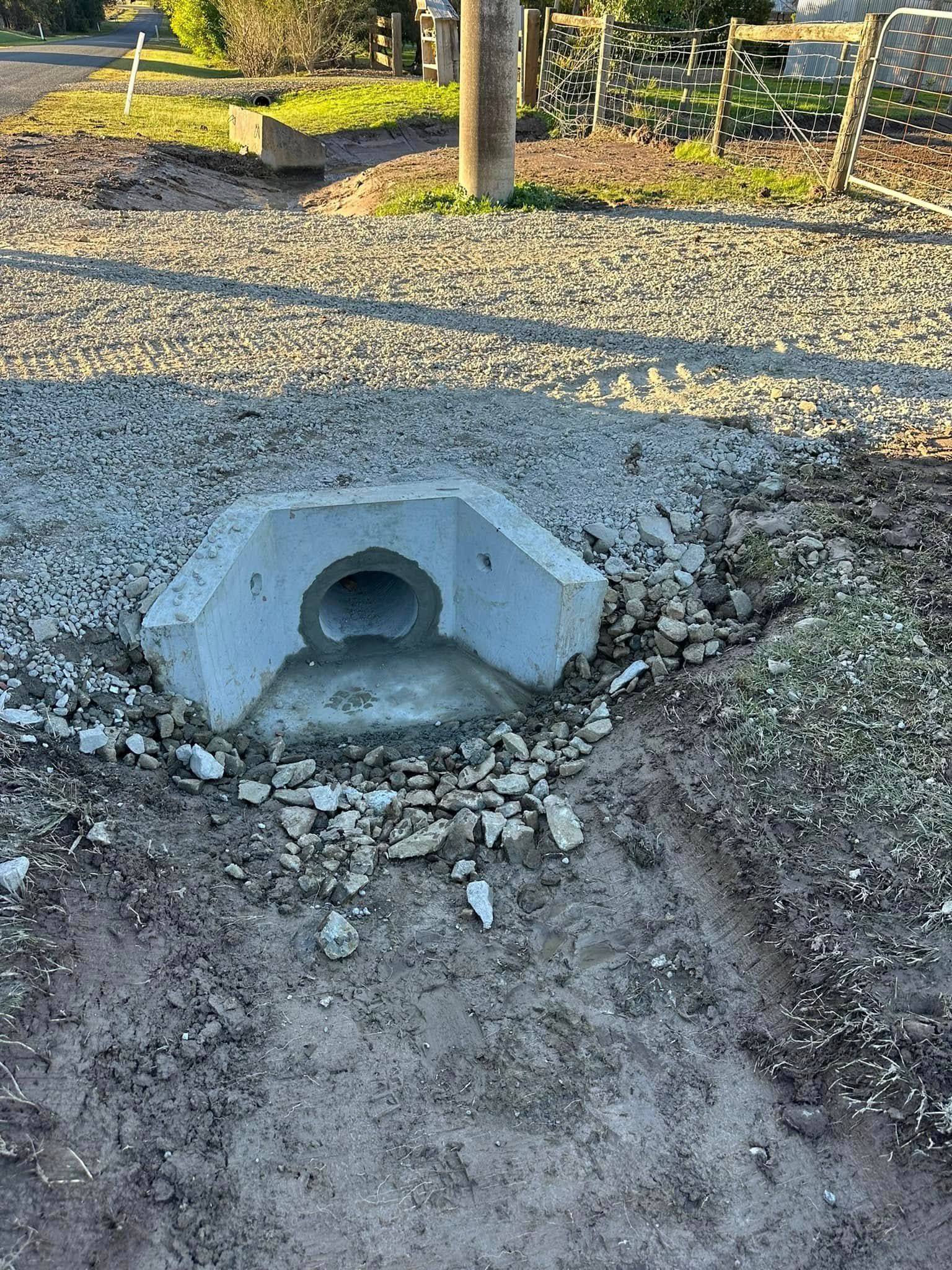 A truck is driving down a dirt road next to a field.