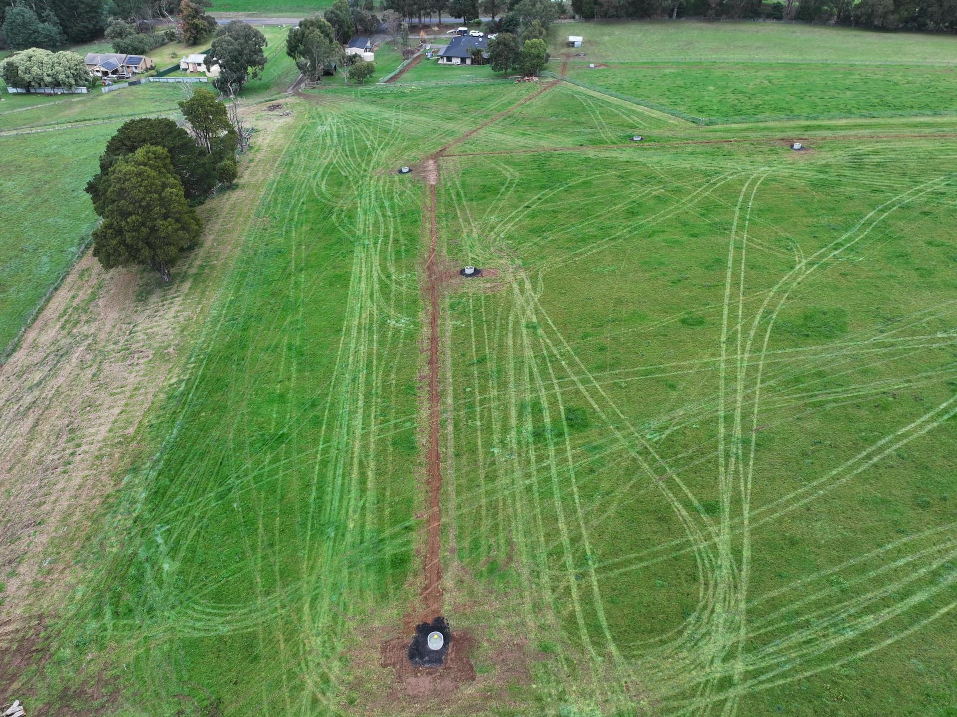 A stream running through a field of rocks and grass.