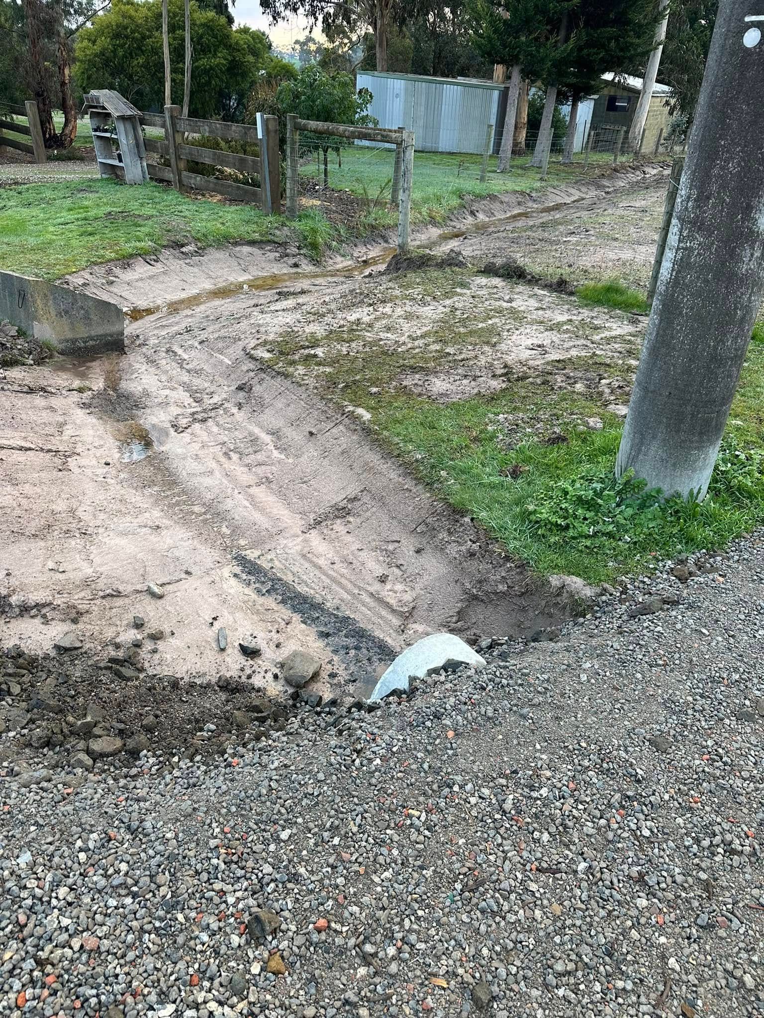A pile of gravel is sitting in the middle of a dirt road.