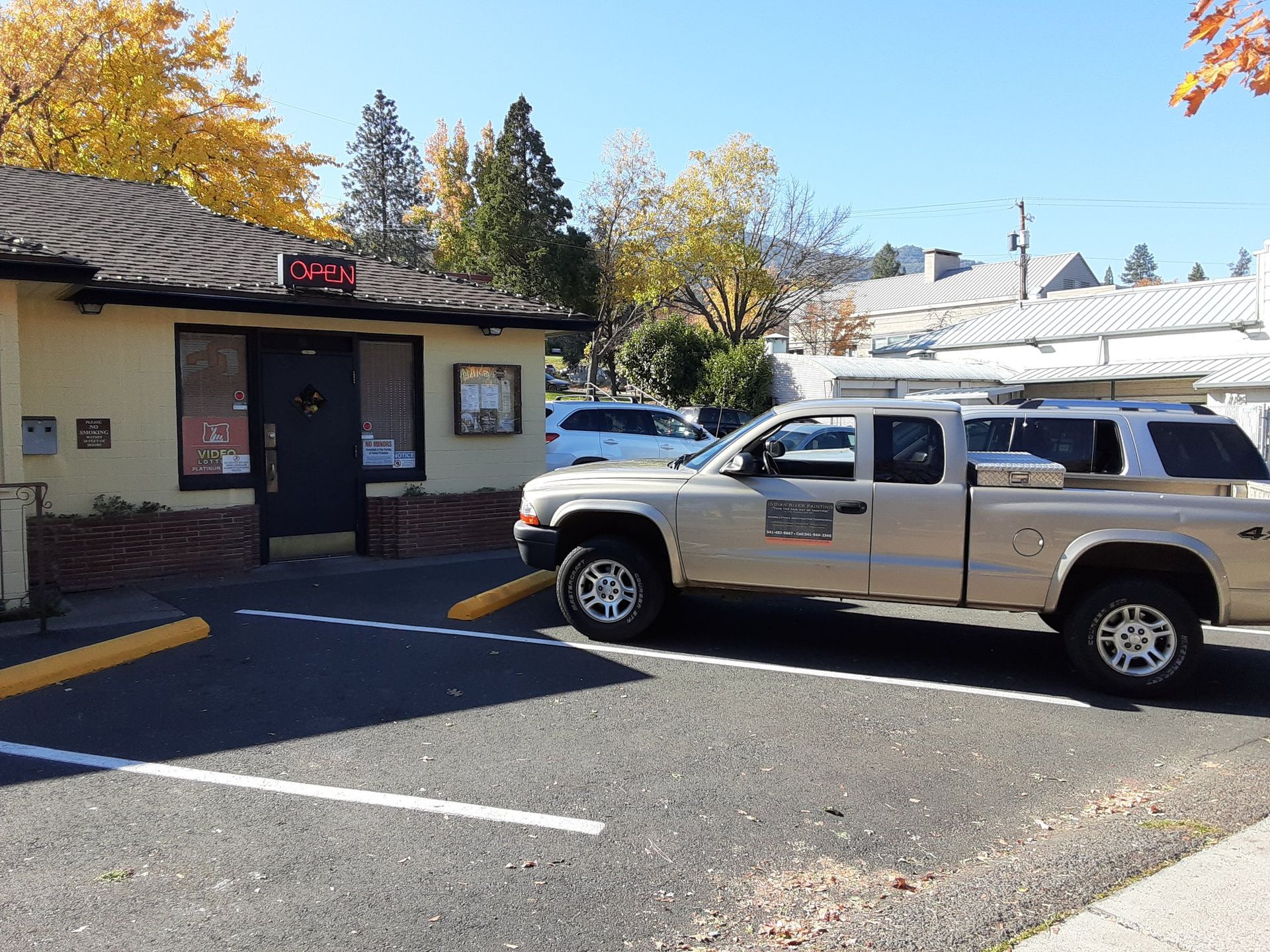 A truck is parked in front of a building on a sunny day.