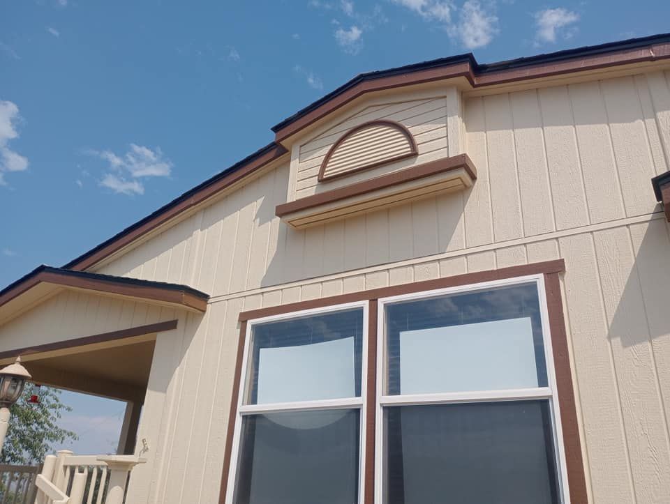 A house with two windows and a porch on a sunny day