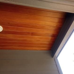 A close up of a wooden ceiling with a ceiling fan.