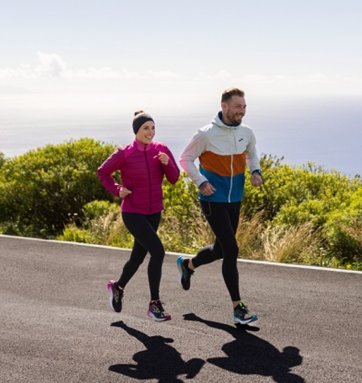 A man and a woman are running down a road