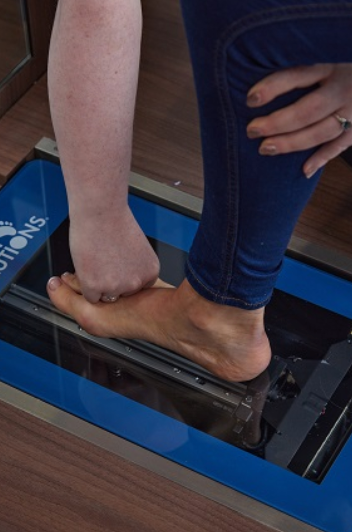 A person 's foot is being measured in a machine that says shoes