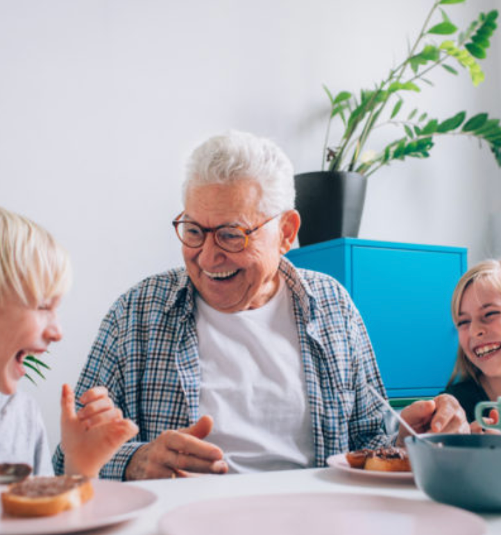 A man and two children are sitting at a table eating food.