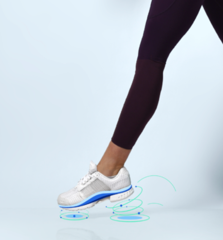 A person wearing purple leggings and white sneakers is walking