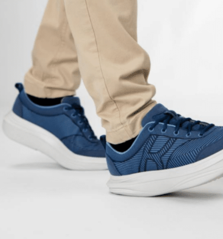 A person wearing a pair of blue sneakers with white soles