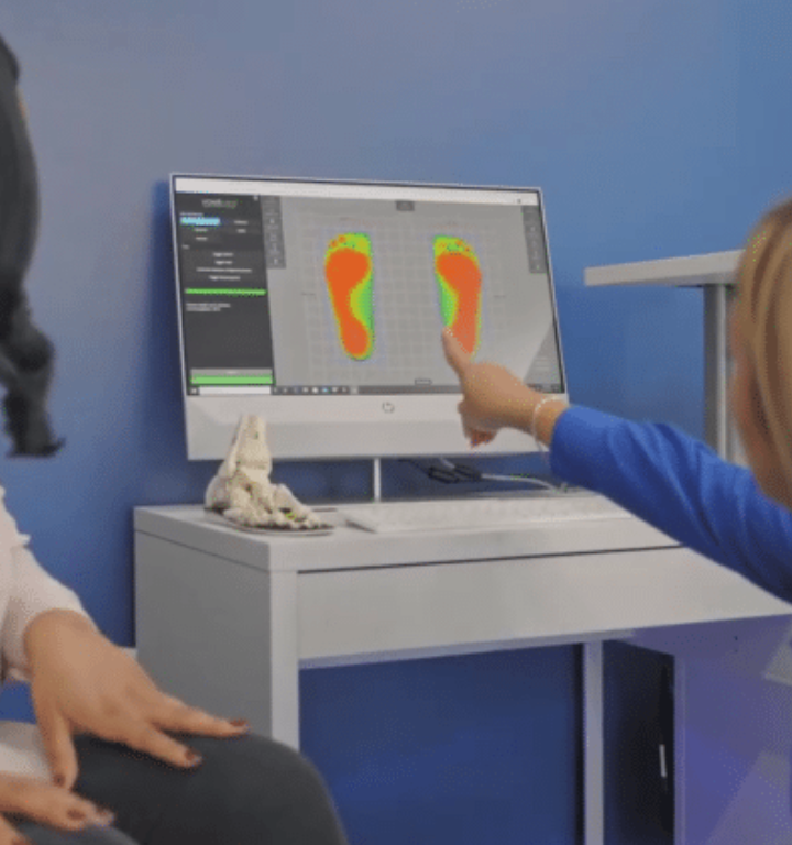 A person pointing at a computer screen with footprints on it