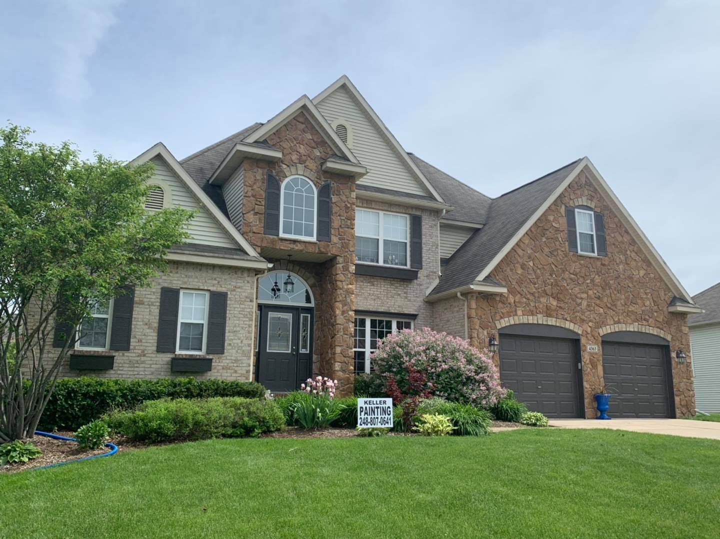 Professionally painted siding, window trims, and shutters on a home in Southeast Michigan
