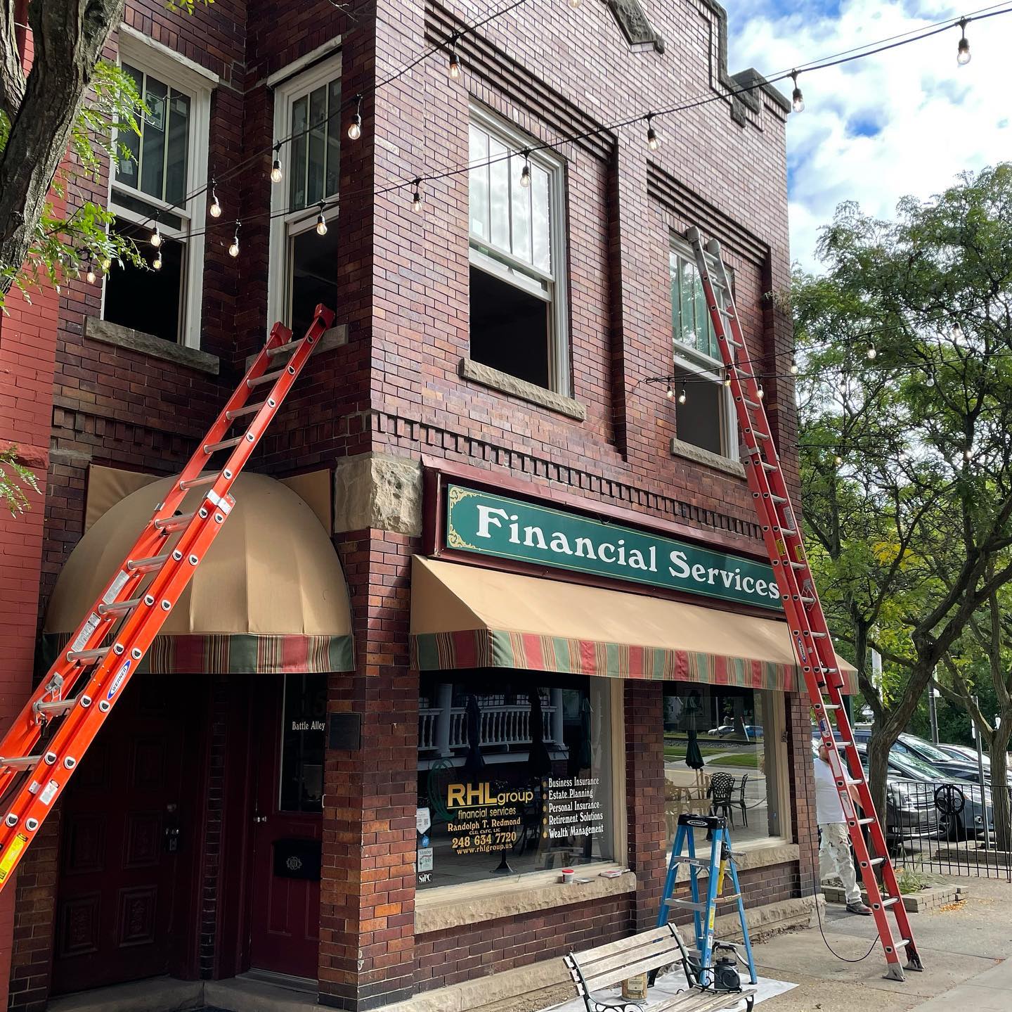 A commercial brick building in downtown Holly in the process of having their windows professionally painted