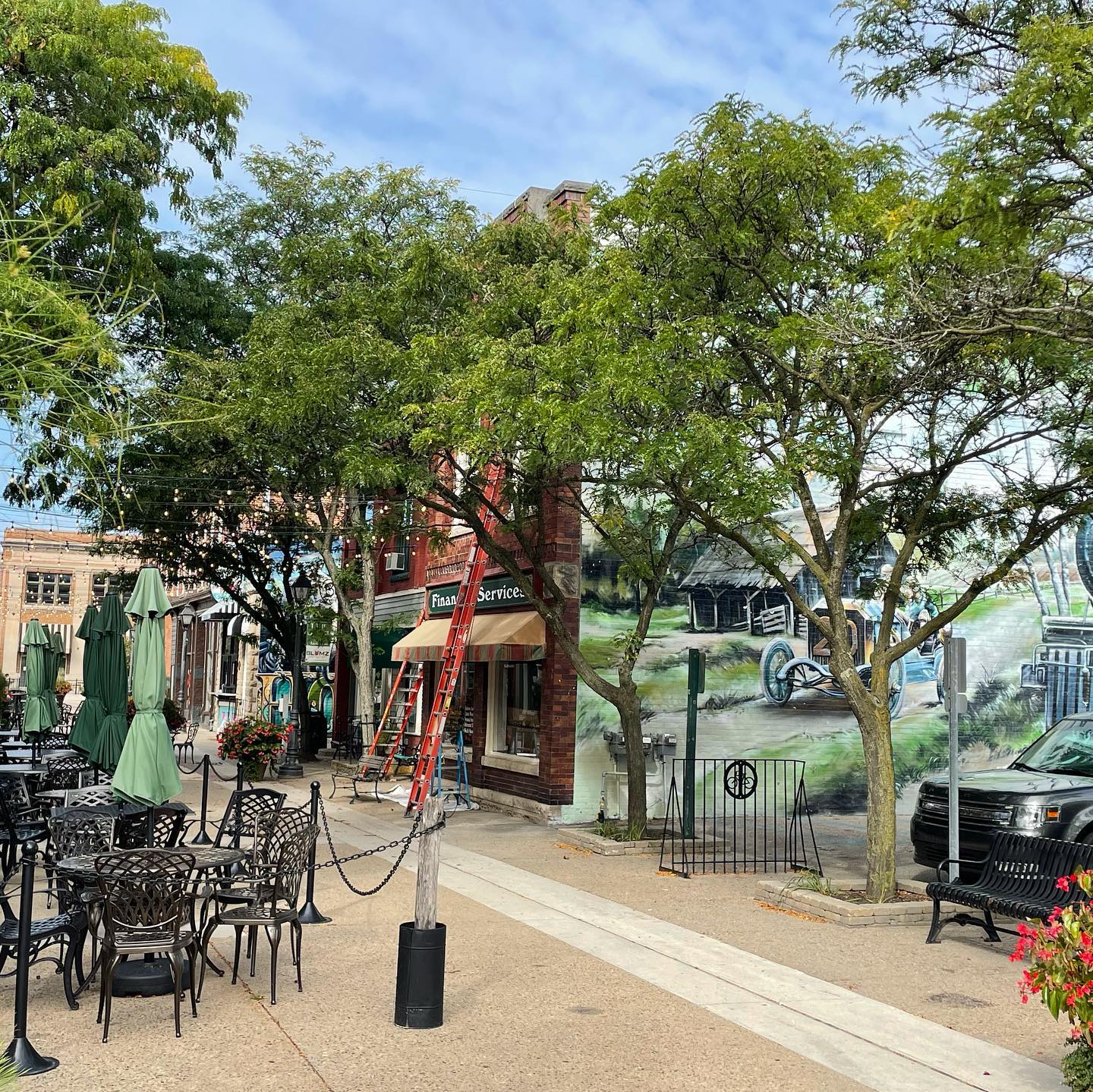 Wooden windows of a downtown Holly commercial building being painted by expert painters
