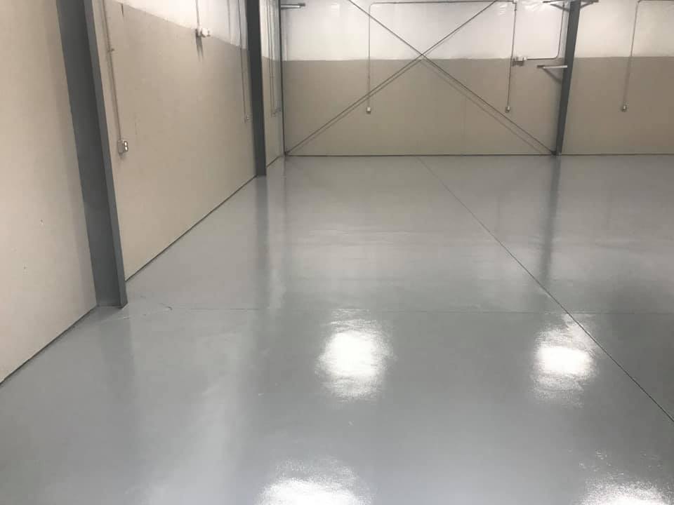 Industrial painting of a warehouse’s floor in the process of drying