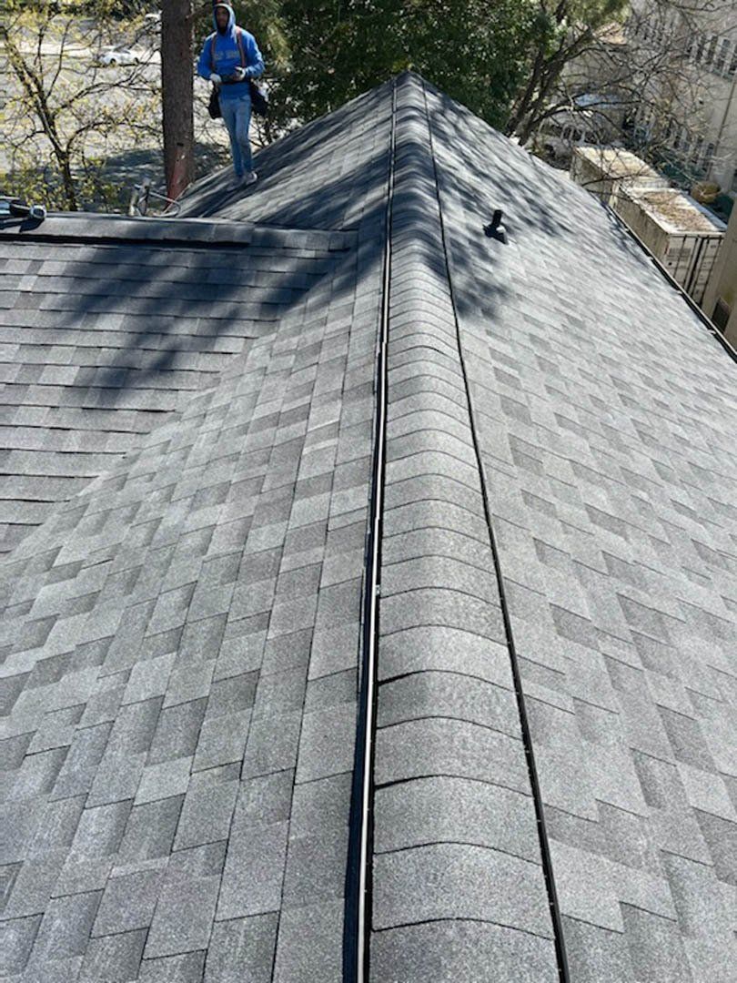 A man is standing on the roof of a house.