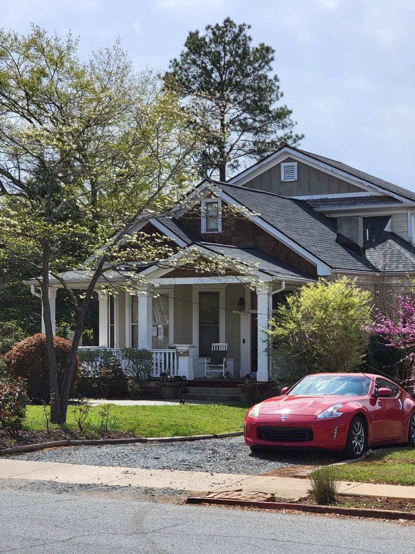 A red car is parked in front of a house