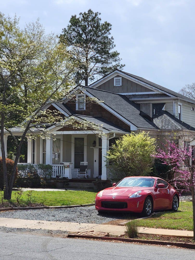 A red sports car is parked in front of a house