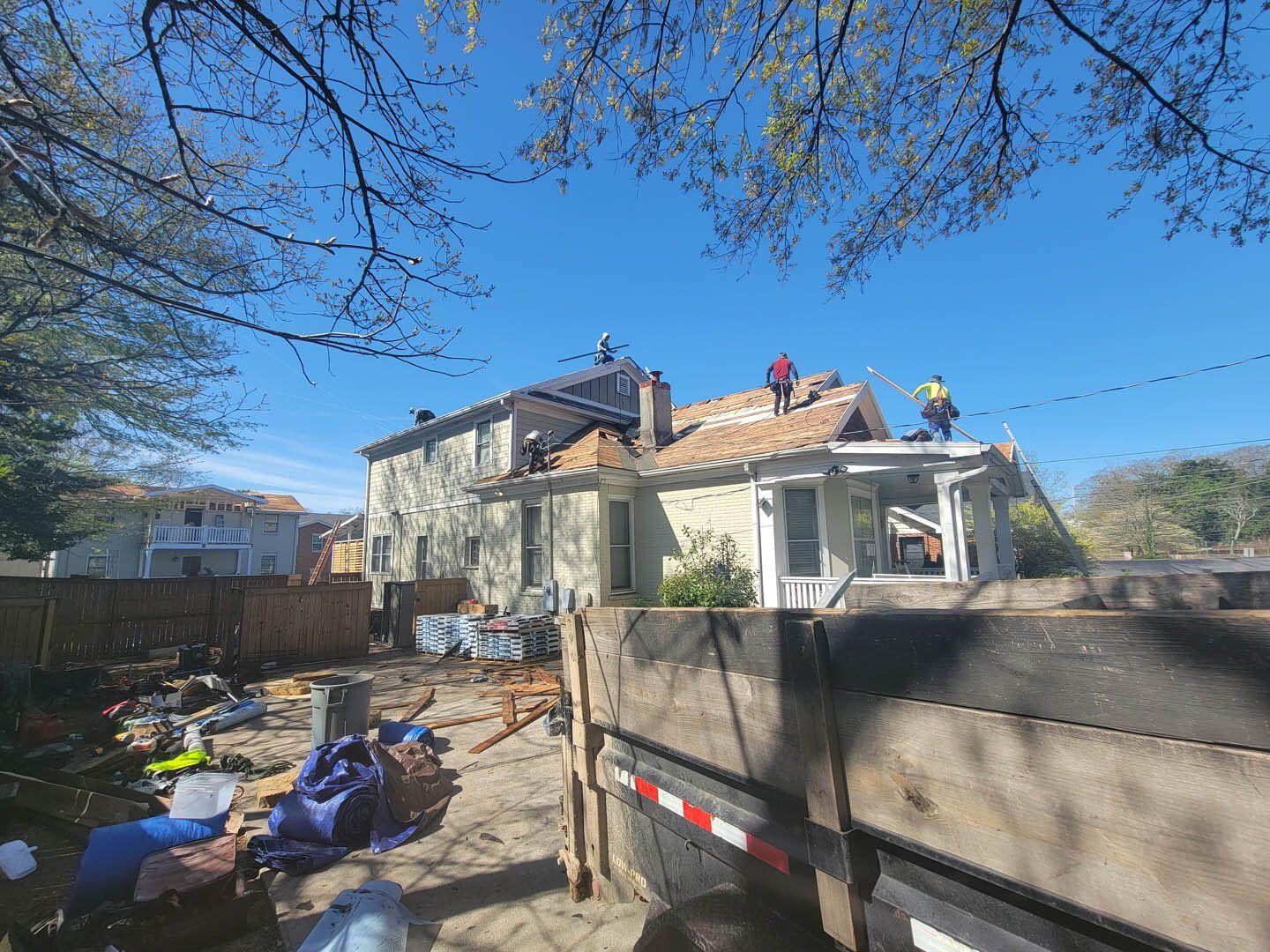 A group of people are working on the roof of a house.