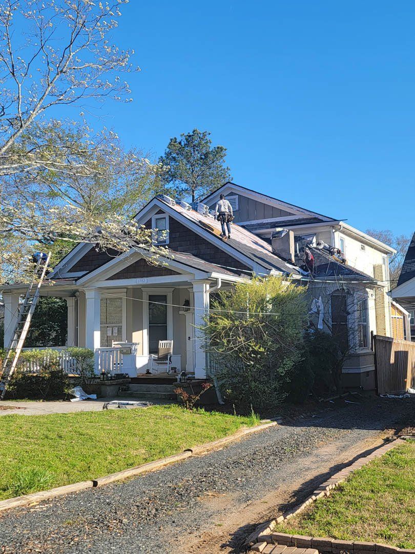 A white house with a roof that is being repaired.