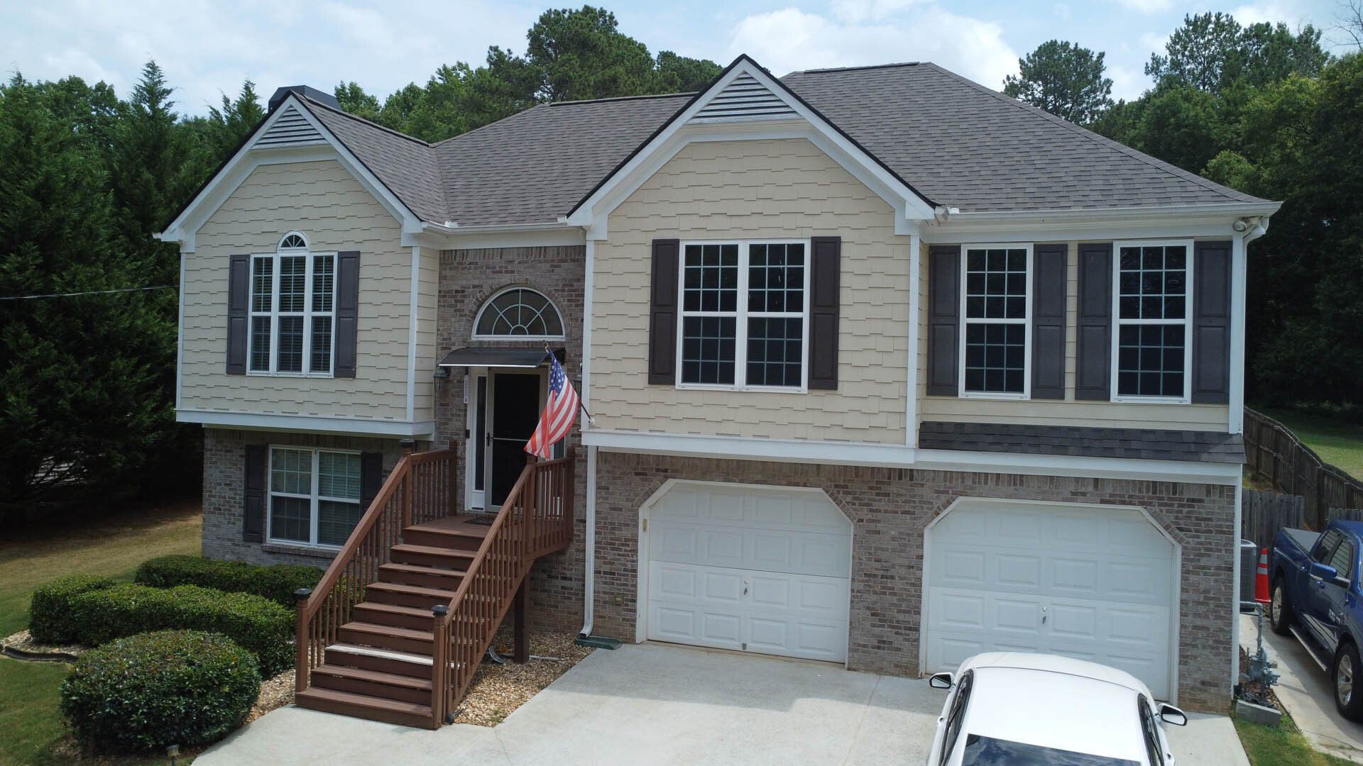 An aerial view of a large house with a car parked in front of it.
