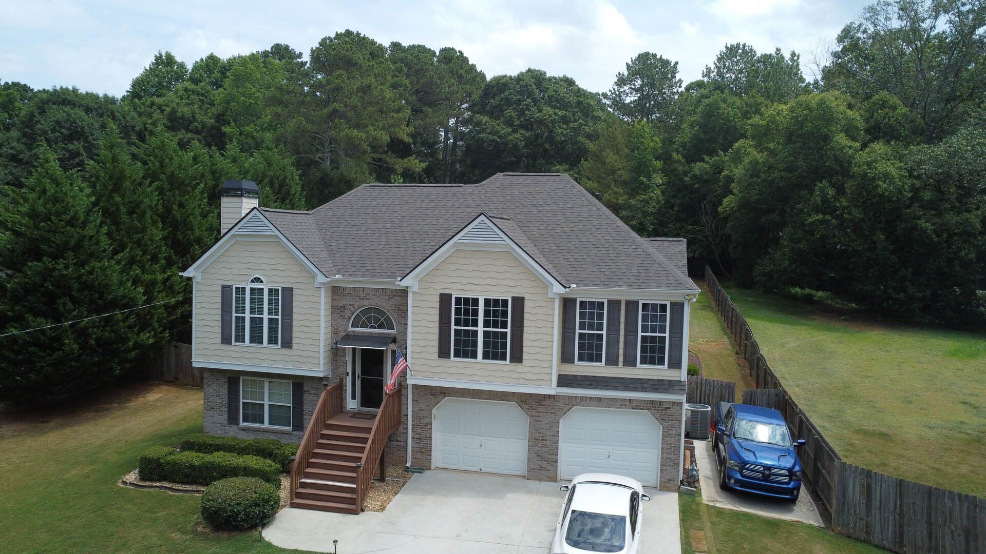 An aerial view of a large house with a car parked in front of it.