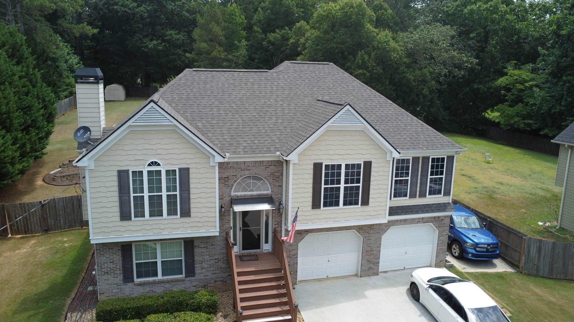An aerial view of a large house with a car parked in front of it.