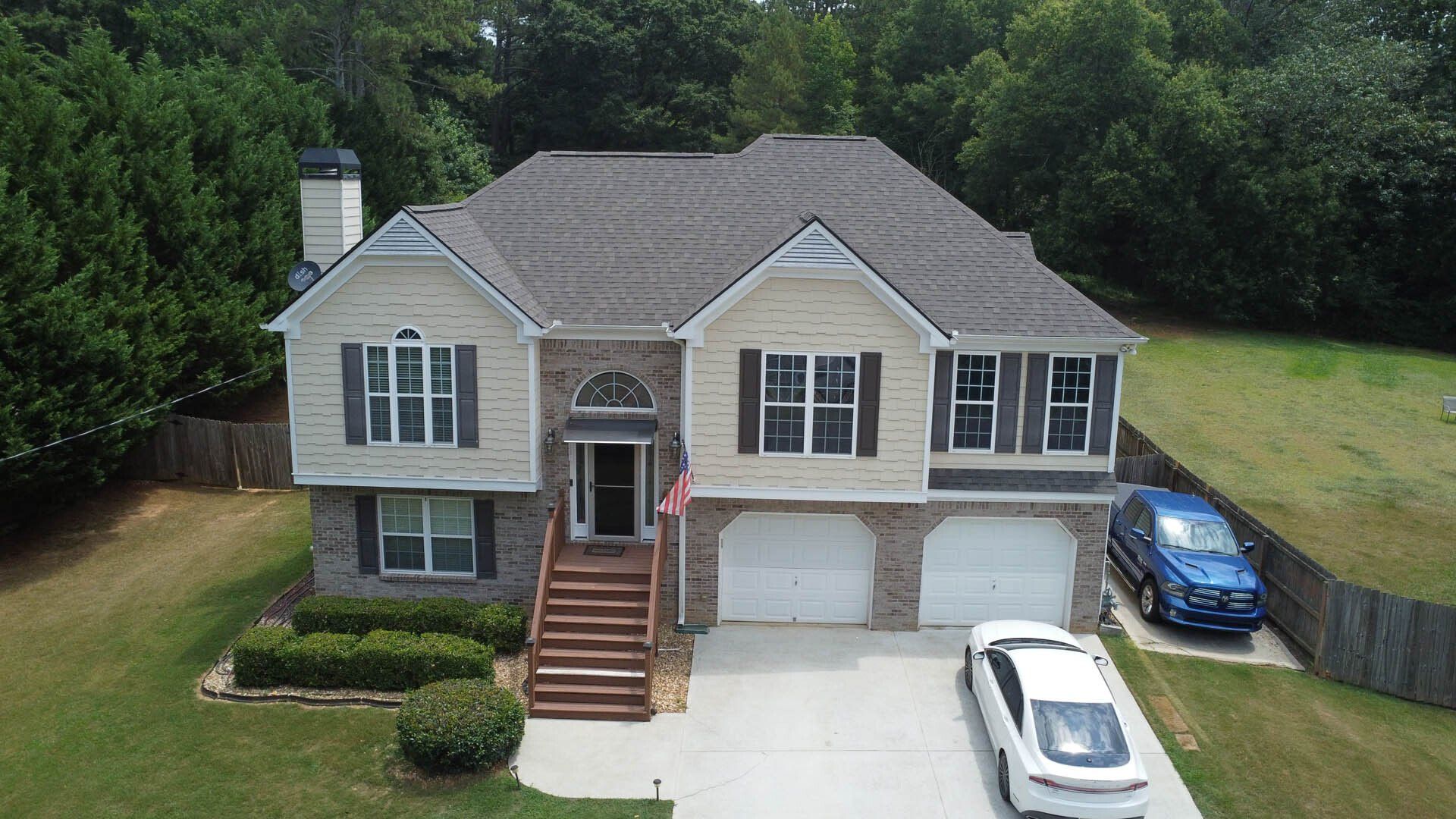 An aerial view of a large house with a car parked in front of it.